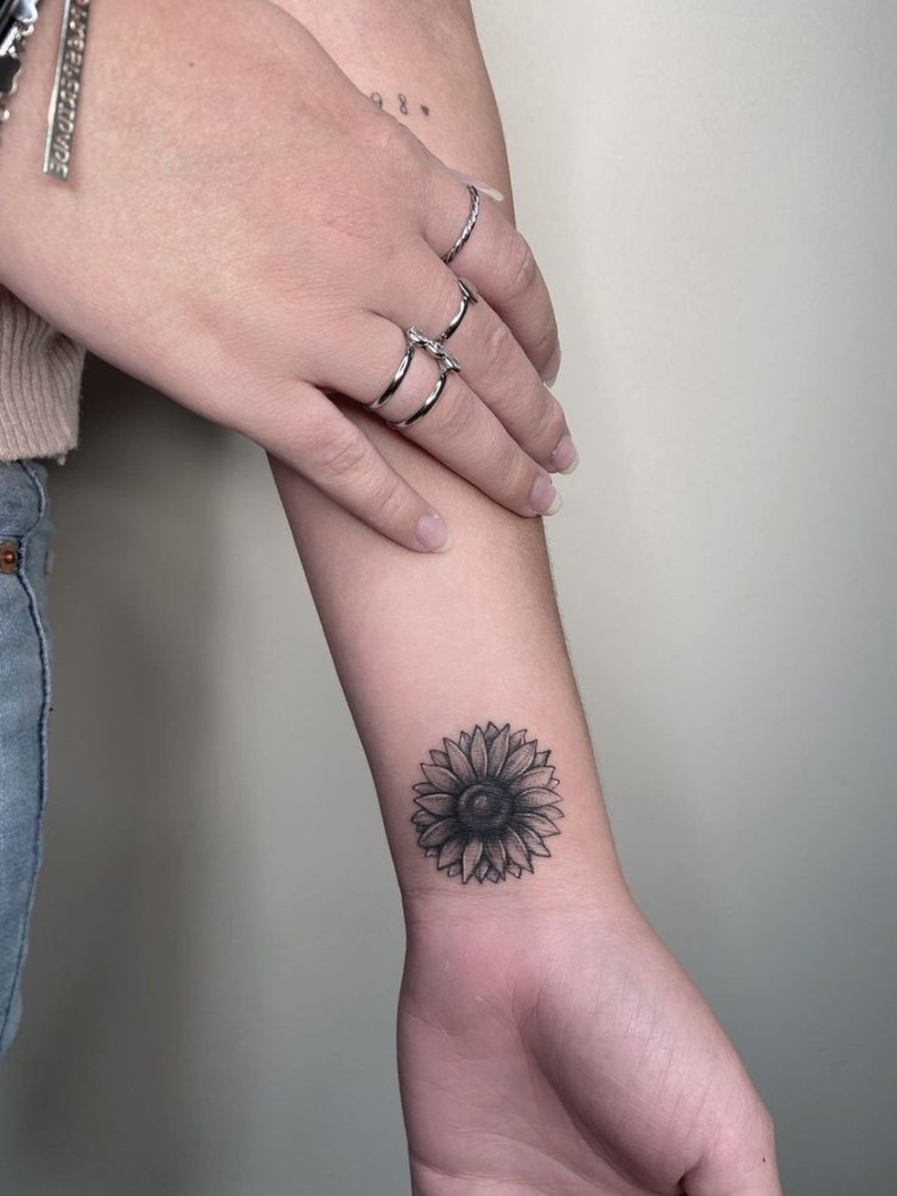 tatuagem feminina de flor de lótus no pulso significado