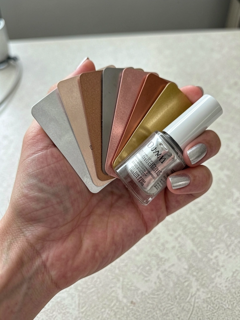Leque de amostras de esmalte metalizado em tons variados sobre mesa clara